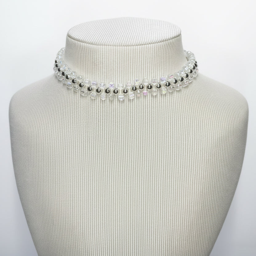 Necklace on a mannequin bust with a plain background