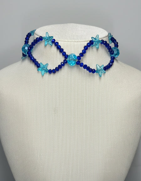 Blue beaded infinity necklace on a mannequin head against a gray background
