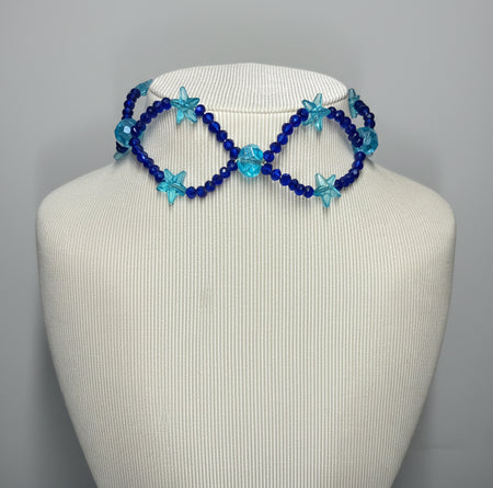 Blue beaded infinity necklace on a mannequin head against a gray background