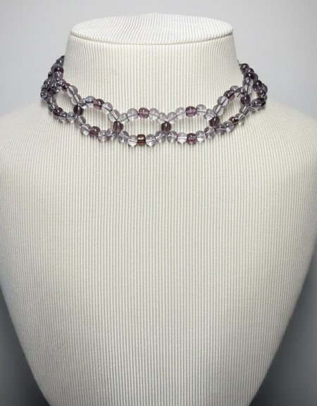 Necklace on a mannequin bust against a plain background