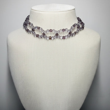 Necklace on a mannequin bust against a plain background